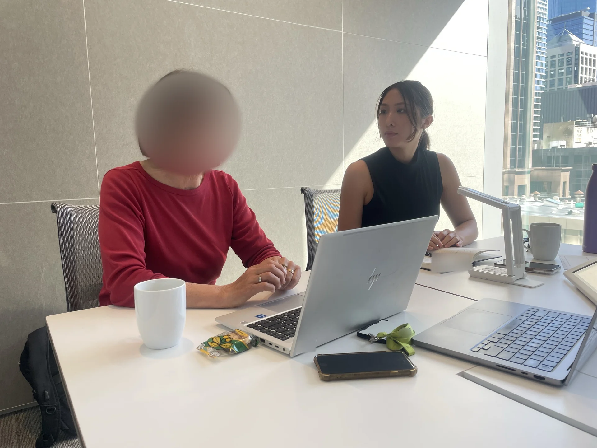 Kim seated with a customer during a research session; the customer’s face is blurred